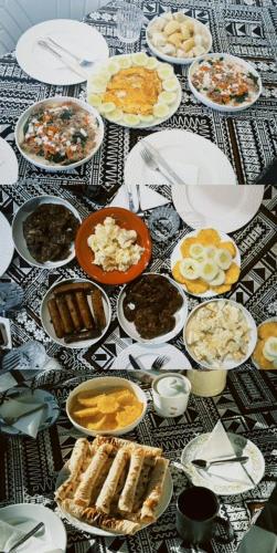 a table with many plates of food on it at Max's Beachside homestay room 2 in Nalauwaki