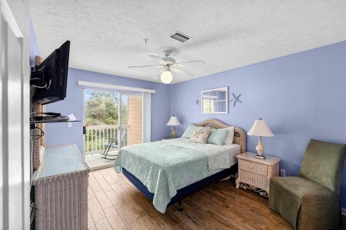 ein Schlafzimmer mit einem Bett, einem Fernseher und einem Stuhl in der Unterkunft Peachtree Place Ii C202 in Panama City Beach