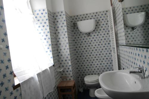 a bathroom with a sink and a toilet and a window at Borgo al Cielo - Albergo Diffuso in Suvereto