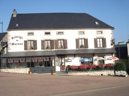 een groot wit gebouw met bloemen ervoor bij Auberge du Morvan in Alligny-en-Morvan