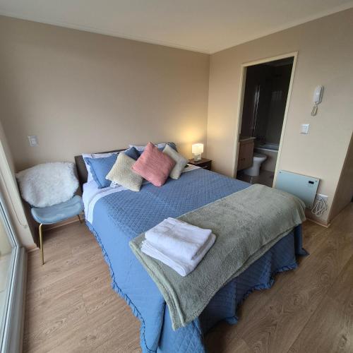 a bedroom with a blue bed with towels on it at Departamento Central Osorno 2 in Osorno
