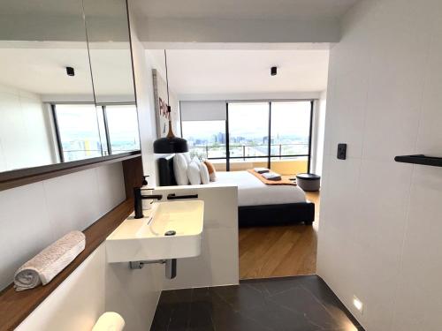 a bedroom with a bed and a sink and a mirror at Panoramic City Views! - Large Luxury 2 Bedroom Apartment in Brisbane