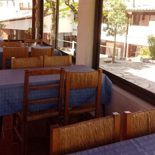 a dining room with tables and chairs and a window at Ribera Sur Hotel - Los Algarrobos - Tanti in Tanti