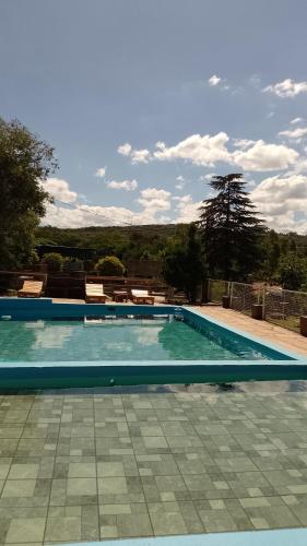 a large swimming pool with blue water at Ribera Sur Hotel - Los Algarrobos - Tanti in Tanti