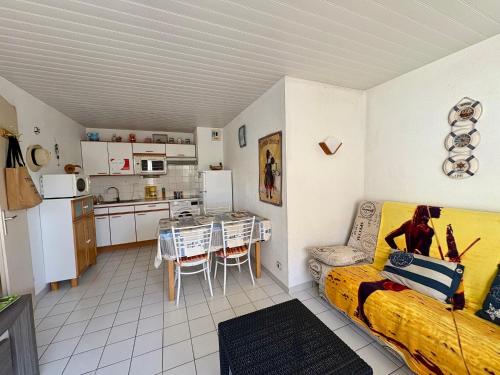 un salon avec un canapé et une table et une cuisine dans l'établissement Appartement calme avec terrasse, garage, proche plage et marché - Saint-Jean-de-Monts - FR-1-323-145, à Saint-Jean-de-Monts