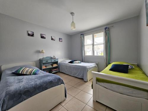 a bedroom with two beds and a window at Maisonnette près du centre, proche plage et commerces - FR-1-476-84 in LʼAiguillon-sur-Mer