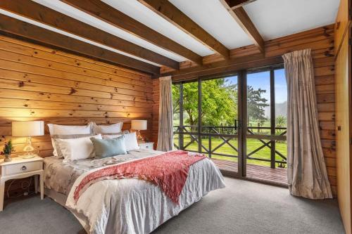 a bedroom with a bed and a large window at The Wee Glen - Peaceful Country Retreat in Bennetts