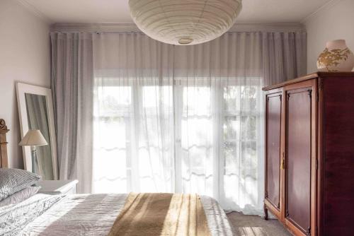 a bedroom with a bed and a large window at Fitzs Folly in New Plymouth