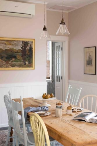 a dining room with a wooden table and chairs at Fitzs Folly in New Plymouth
