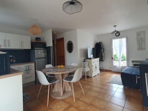 une cuisine et une salle à manger avec une table et des chaises dans l'établissement Charmante Maison T3 avec Jardin, Proche Plage et Commerces, Animaux Admis sur Demande - FR-1-476-206, à Grues