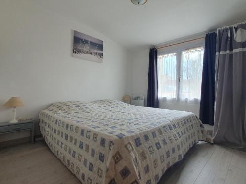 une chambre avec un lit avec une couette dessus dans l'établissement Charmante Maison T3 avec Jardin, Proche Plage et Commerces, Animaux Admis sur Demande - FR-1-476-206, à Grues