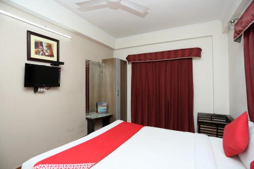 a bedroom with a bed and a red curtain at Hotel O Relax in Gwalior