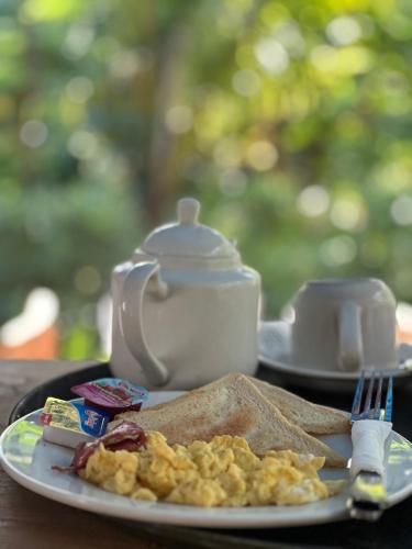een bord met eieren en toast en een waterkoker bij The Dulu Penida in Nusa Penida