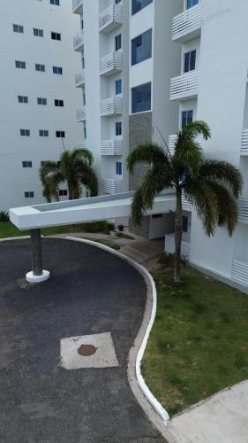 a white building with palm trees in a parking lot at Playa Blanca escapada perfecta con vista al mar y piscina en Río Hato in Playa Blanca