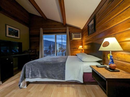 a bedroom with a bed and a large window at Merritt Lodge in Merritt