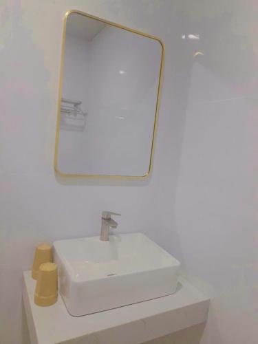 a bathroom with a white sink and a mirror at Khách sạn LyLy 3 in Thuan An