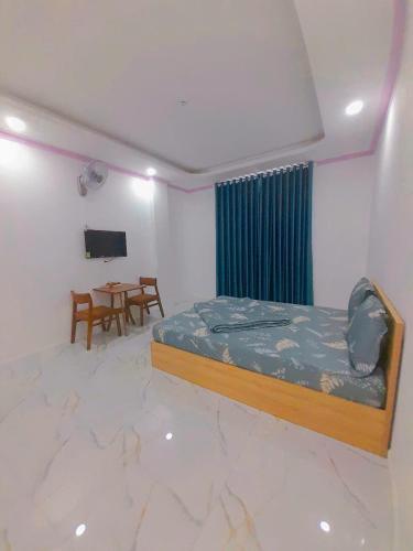 a bedroom with a bed and a table in it at Khách sạn LyLy 3 in Thuan An