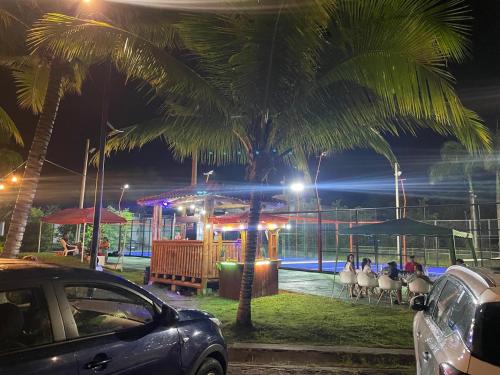 a group of people sitting in chairs under palm trees at night at Vacaciones Playa Club Casa Blanca Same Esmeraldas in Same
