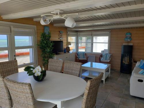 une salle à manger avec une table et des chaises blanches dans l'établissement ARCADAMOUSSE Maison en bord de mer Granville baie du Mont Saint Michel, à Granville