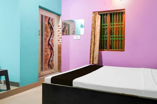 a bedroom with colorful walls and a bed with a window at Hotel O The Shivansh Inn in Cuttack