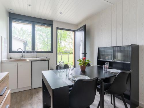 - une cuisine avec une table à manger et des chaises dans l'établissement Studio Neuf pour 2 à Parentis-en-Born – Ménage Inclus - FR-1-319-608, à Parentis-en-Born