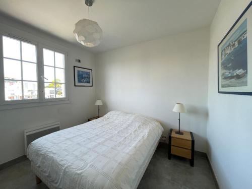 une chambre blanche avec un lit et deux fenêtres dans l'établissement Arcachon - Beau T2 avec grande terrasse vue port - FR-1-420-158, à Arcachon