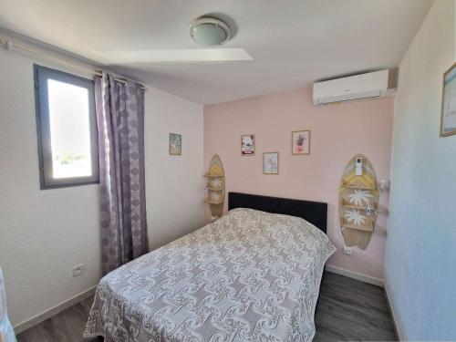 une petite chambre avec un lit et une fenêtre dans l'établissement Appartement rénové à Marseillan avec terrasse ensoleillée - FR-1-387-213, à Marseillan