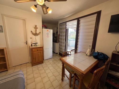 une salle à manger avec une table et un réfrigérateur dans l'établissement Pavillon 2 Pièces avec Jardin, 4 Personnes, Terrasse - FR-1-701-91, à Vendres