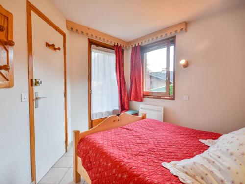 - une chambre avec un lit rouge et une fenêtre dans l'établissement Appartement lumineux 39m², 4 pers, proche centre Morzine - FR-1-684-71, à Morzine
