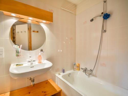 une salle de bain avec un lavabo, une baignoire et un miroir dans l'établissement Appartement lumineux 39m², 4 pers, proche centre Morzine - FR-1-684-71, à Morzine