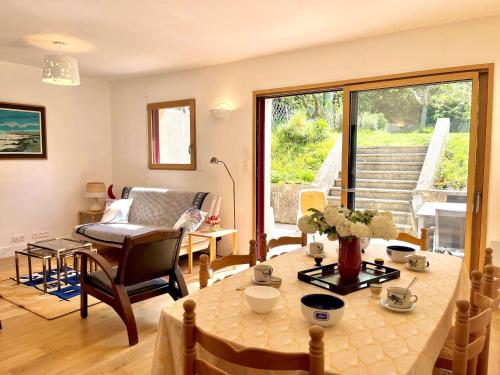 un salon avec une table et une chaise dans l'établissement Maison T5 atypique rénovée PMR – Centre de Locmiquélic – Classée 2* - FR-1-479-228, à Locmiquélic