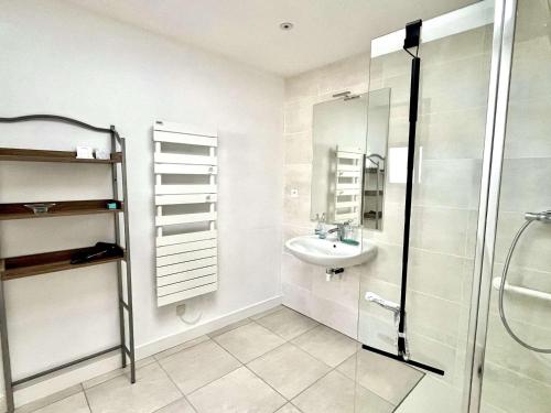 une salle de bain blanche avec un lavabo et une douche dans l'établissement Maison T5 atypique rénovée PMR – Centre de Locmiquélic – Classée 2* - FR-1-479-228, à Locmiquélic