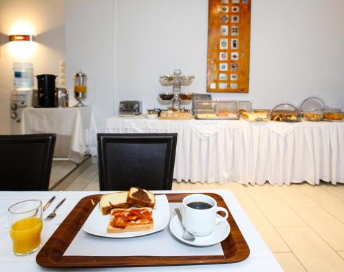 a table with a plate of food and a cup of coffee at Hotel Astron in Kardítsa