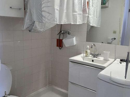 une salle de bain avec un lavabo, des toilettes et un miroir dans l'établissement Pavillon 3 Pièces, Terrasse, Narbonne Plage - FR-1-229B-110, à Narbonne