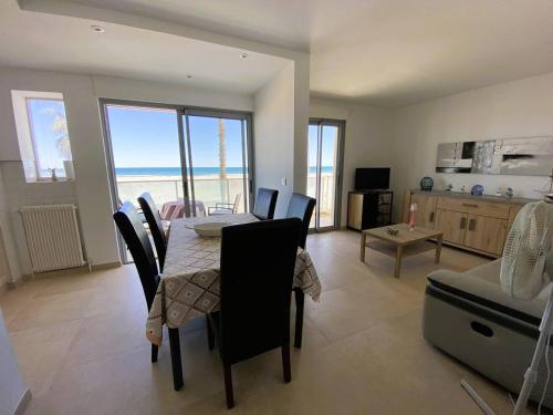 une salle à manger avec une table et une chambre avec l'océan dans l'établissement Appartement 3 pièces, proche plage, parking - FR-1-750-94, à Canet