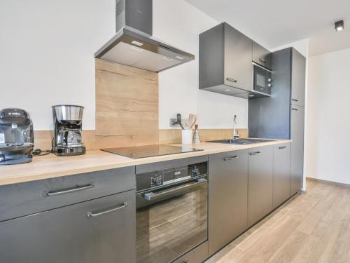 Il comprend une cuisine avec des appareils en acier inoxydable et du parquet. dans l'établissement Morzine Centre 5 pers, Appartement Neuf avec Balcon - FR-1-684-70, à Morzine