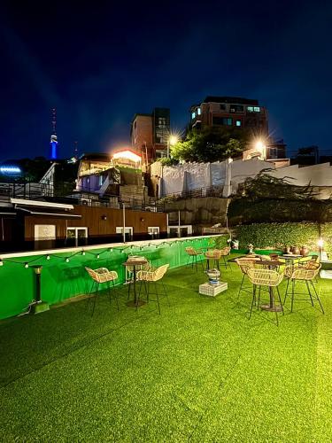 un gruppo di sedie e tavoli su un tetto notturno di Look Home Guesthouse a Seul