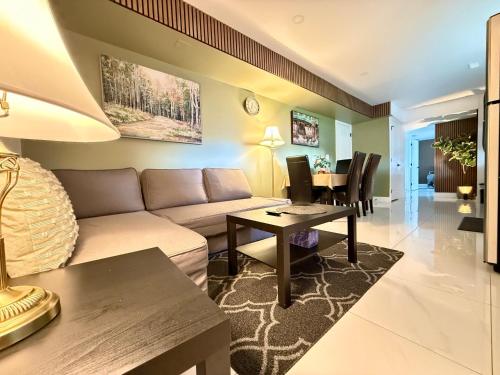 a living room with a couch and a table at Brand New 2 Bedroom Suite in Langley Twp - Play Area, Patio & Mini Golf in Aldergrove