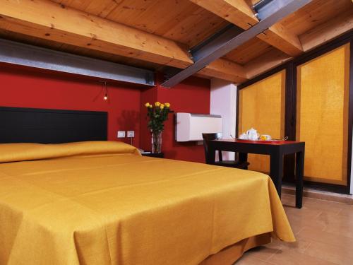 a bedroom with a yellow bed and a table at Casepicarmo Guest House in Augusta