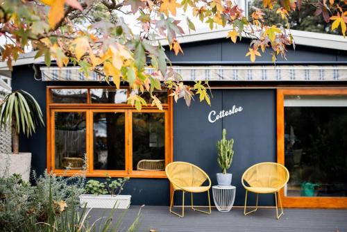 two chairs sitting in front of a building at Cottesloe Beach Shack Barwon Heads in Barwon Heads