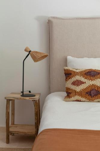 un lit avec une table et une lampe. dans l'établissement Retreat Between Sea And Mountains In Provence, à Saint-Cézaire-sur-Siagne