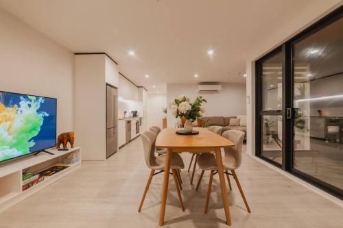 a dining room with a table and a tv at Central 1BR - Bath BBQ & Full Kitchen in Christchurch