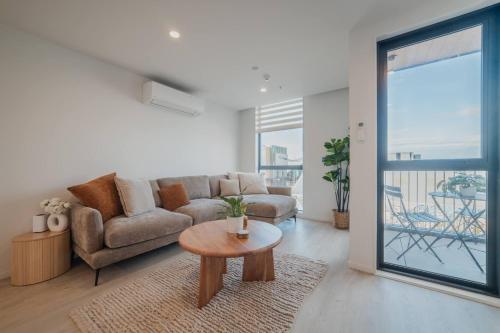 a living room with a couch and a table at Central 1BR - Bath BBQ & Full Kitchen in Christchurch