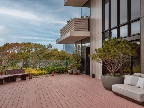 a patio of a building with a bench and a tree at Patina Osaka in Osaka