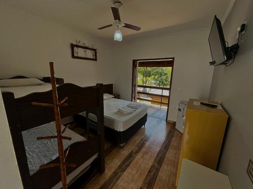a room with two bunk beds and a window at Pousada Pé da Serra in Lindóia