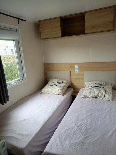 deux lits dans une petite pièce avec une fenêtre dans l'établissement Bungalow confortable près de Condrieu avec piscine partagée, à Condrieu