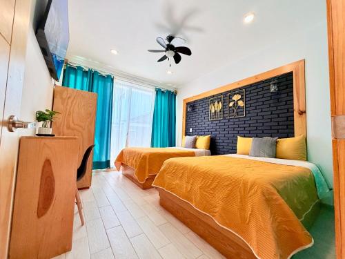 a bedroom with two beds and a ceiling fan at CASA VILLA DEL SOL con alberca climatizada in Tonatico