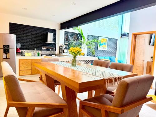 a kitchen with a wooden table and chairs at CASA VILLA DEL SOL con alberca climatizada in Tonatico