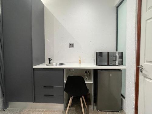 ロードポートにあるStay In Carlazo - Unlimited WiFi Solar backupの小さなキッチン(シンク、黒い椅子付)