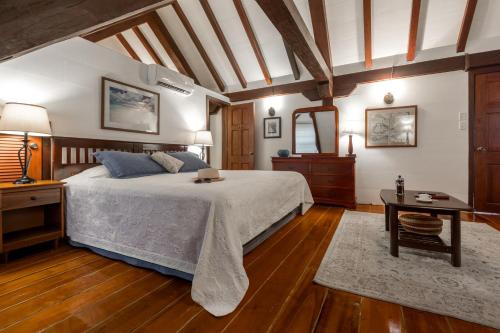 a bedroom with a large bed and a table at Admiral's Inn and Gunpowder Suites in English Harbour Town